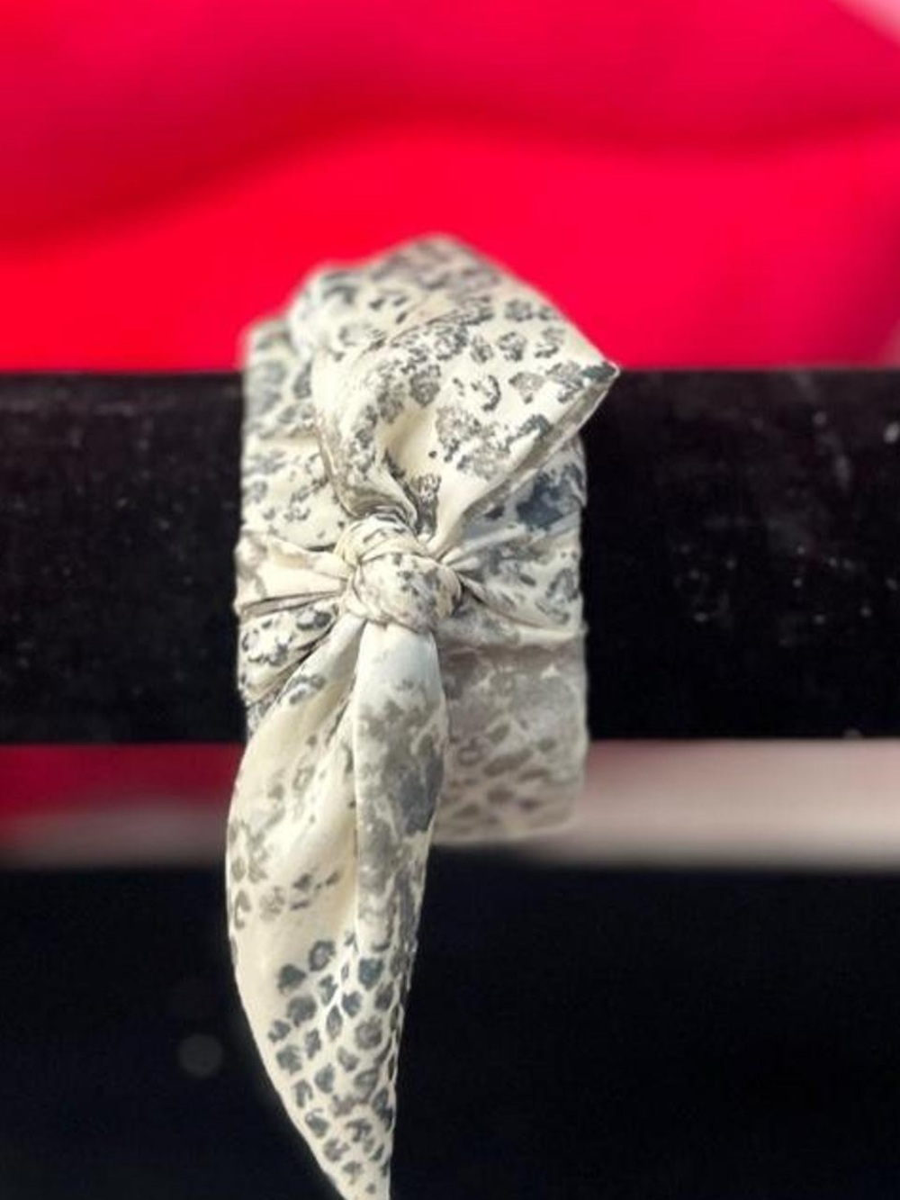 Fabric hinged clamp bangle bracelet with white grey and a bow on top